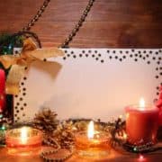 Weihnachtsdekoration mit Briefumschlag, Kerzen und Christbaumschmuck